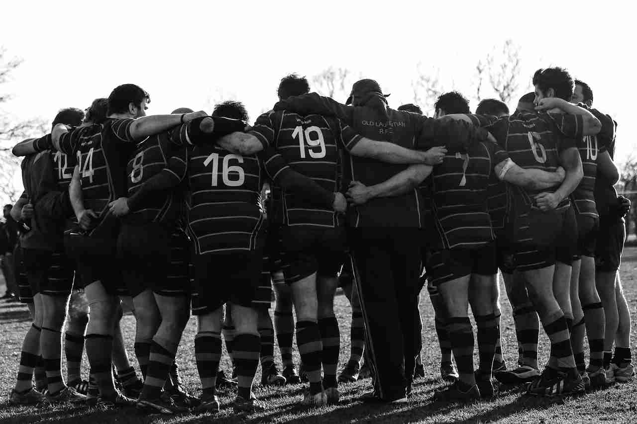 team of rugby players huddling together