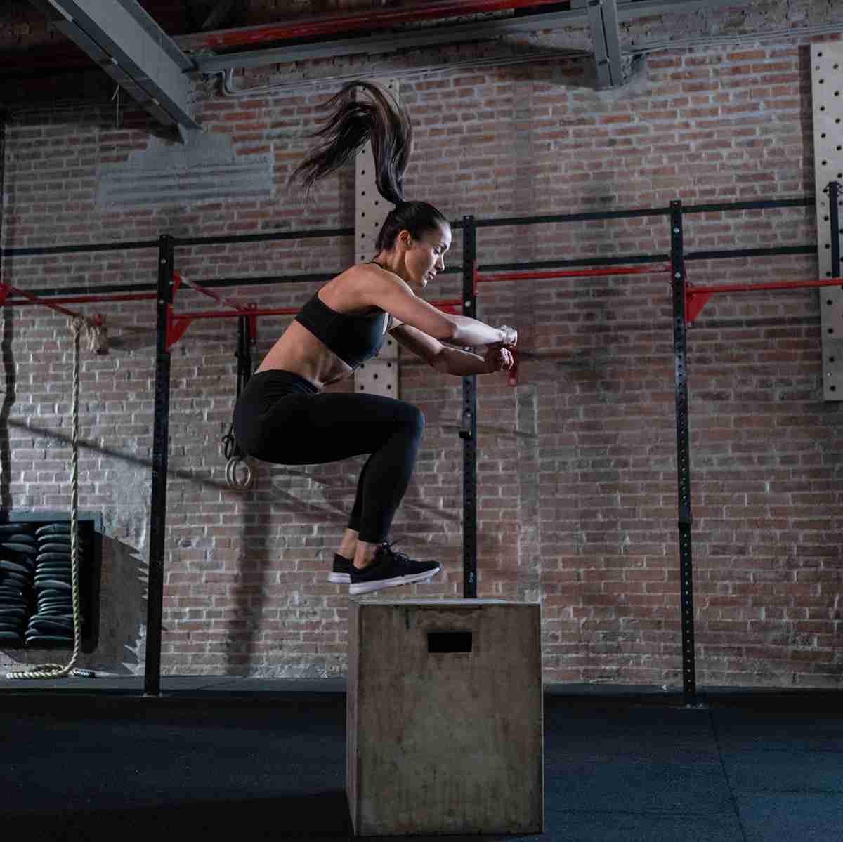 athlete in gym doing a box jump
